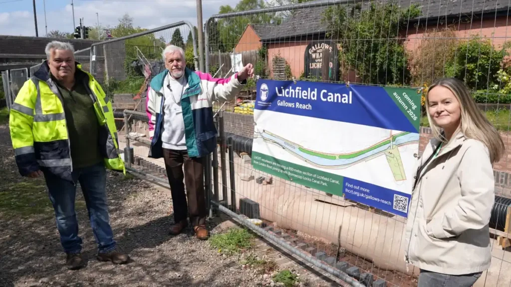 M6toll representative with LHCRT volunteers beside the Lichfield Canal Gallows Reach restoration sign